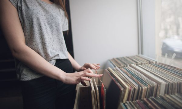 Choosing retro vinyl records. Music background Choosing retro vinyl records. Music background. Unrecognizable woman in musical shop, old school hipster style